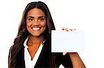 Cheerful businesswoman holding small blank whiteboard, ad space concept.