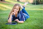 Smiling Young Woman Using Computer Tablet Outdoors at the Park.