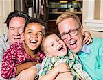 Gay parents and their children pose for a photo at home