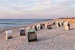 Beach chairs on the beach with dunes on the Baltic Sea in Germany at sunset