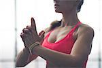 Partial view closeup of fit woman's hands in yoga pose in loft gym