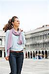 Strolling through St. Mark's Square in Venice, an elegant tourist holds her scarf as she makes her way through an almost-empty square. What an amazing feeling to have it virtually all to herself.