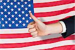 Hand showing thumbs up against rippled us flag