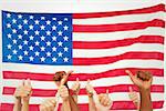 Hands giving thumbs up against rippled us flag
