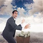 Excited businessman catching against blue sky