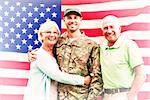 Soldier reunited with parents against rippled us flag