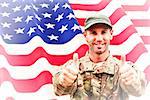 Soldier showing thumbs up against rippled us flag