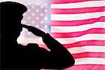 soldier silhouette  against rippled us flag