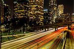 View of highway and city skyscrapers at night, Los Angeles, California, USA