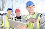 Surveyor and architects using digital tablet on construction site