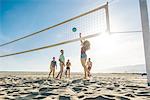 Group of friends playing volleyball on beach