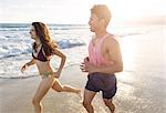 Young couple on running along beach