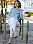 Portrait of elegant mature woman sitting on patio chair