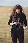 A woman taking a picture with an old fashioned medium format camera.