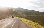 Rear view of car traveling on rural road near Torrey, Utah, USA