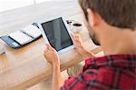 Man using tablet on wooden table