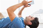 Businessman lying on the floor using tablet