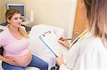 Young pregnant woman talking to her doctor