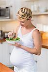 Pregnant woman eating a fresh salad