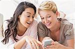 Smiling homosexual couple using smartphone together