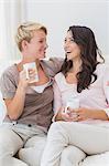 Smiling homosexual couple talking and drinking coffee