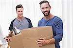 Happy casual businessman holding box