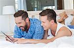 Happy homosexual couple looking at tablet computer