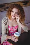 Happy smiling woman drinking coffee and phoning