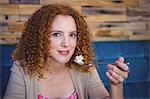 Portrait of a smiling woman taking a piece of a cake