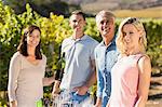 Portrait of smiling sommelier holding wine bottle and her customers