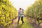 Couple embracing and being about to kiss between grapevine