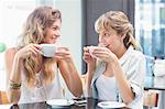 Beautiful women drinking coffee and looking at each other