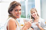 Beautiful women drinking coffee and looking at camera