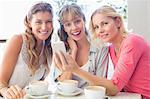 Beautiful women holding mobile phone while looking at camera