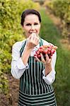 Female winegrower eating red grapes