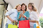 Happy friends showing their shopping bags