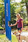 Student with visual impairment and her service dog using Emergency station at school