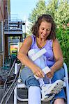 Woman with Spina Bifida adjusting leg brace so she can walk