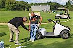 Man with a spinal cord injury in an adaptive cart at golf putting green with an instructor