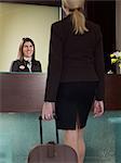 Business woman aproaching porter at hotel front desk