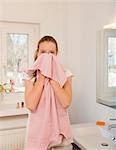 Teenage girl wiping her face with towel