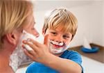 Father and son applying shaving cream