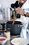 Man grinding pepper into pot