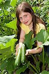 Girl holding cucumbers