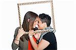 Lesbian couple holding picture frame against white background