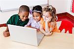 Three children looking at the laptop together