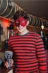 Young man in costume and mask in bar, portrait