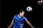 Young man leaping to head soccer ball