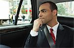 Businessman looking out of window in car