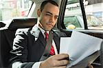 Businessman looking at papers in car